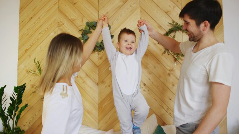 A joyful family moment with parents lifting their smiling child indoors.