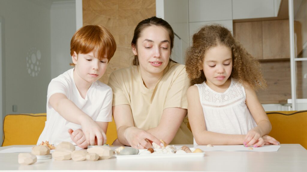 Mother and children engaged in a creative activity at home, fostering bonding and togetherness.